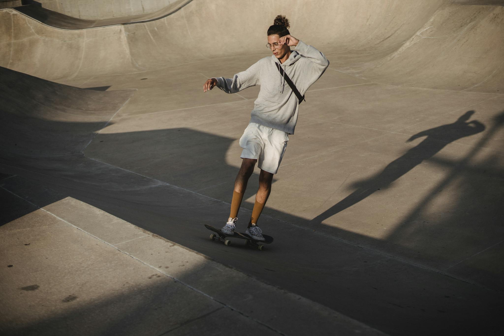 From above full body of determined male athlete riding skateboard on ramp during workout in skate park